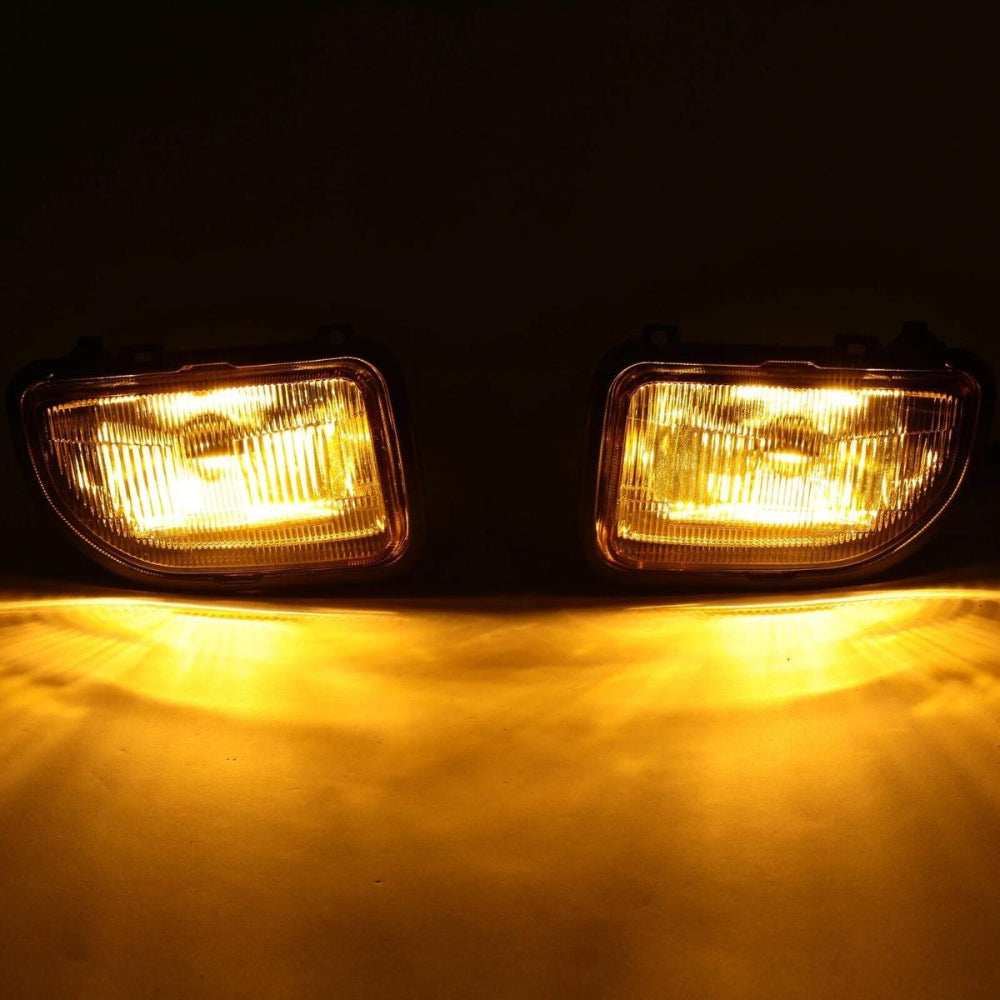 Two illuminated car fog lights on a dark background